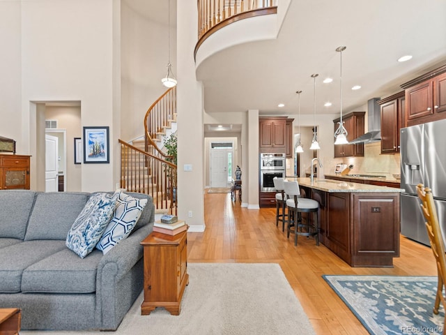 13645 Osage Ct, Broomfield, CO 80023 - living area featuring light wood-style floors, a high ceiling, stairs, and recessed lighting