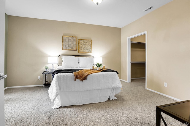 carpeted bedroom featuring baseboards and a spacious closet