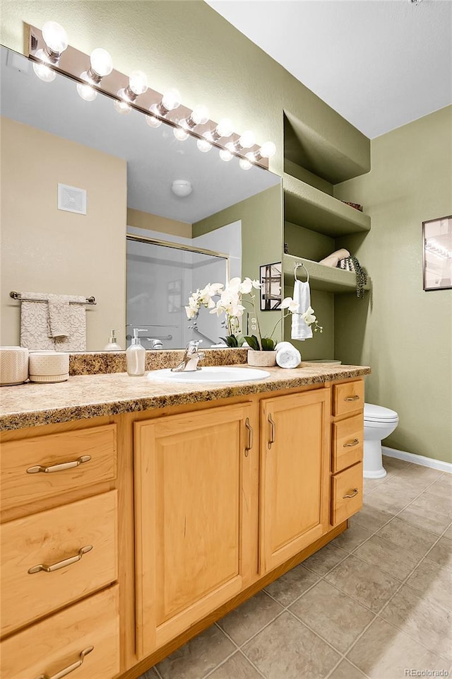 bathroom featuring vanity, tile patterned flooring, a shower stall, toilet, and baseboards