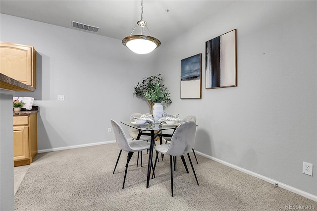 dining room with light colored carpet and baseboards