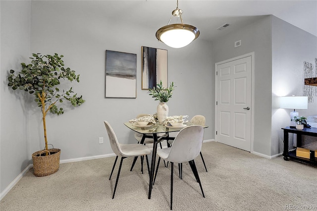 dining room featuring light colored carpet and baseboards