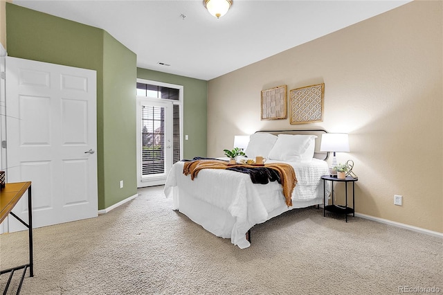 carpeted bedroom with access to exterior and baseboards