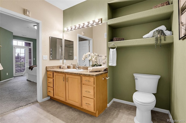 bathroom with vanity, toilet, and baseboards