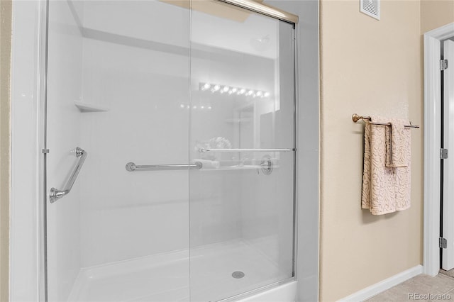 full bath featuring a shower stall and baseboards