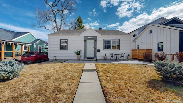 bungalow-style home featuring fence and a front lawn