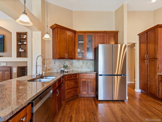 885 Sage Sparrow Cir, Highlands Ranch, CO 80129 - kitchen featuring appliances with stainless steel finishes, brown cabinetry, light stone countertops, and dark wood-style floors