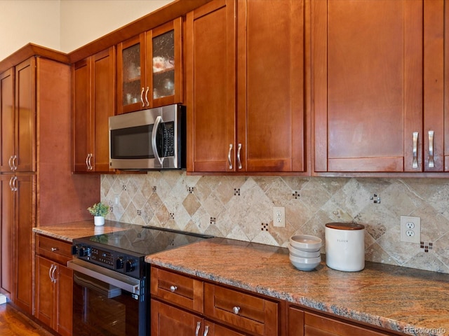 885 Sage Sparrow Cir, Highlands Ranch, CO 80129 - kitchen with stainless steel microwave, electric range oven, stone counters, glass insert cabinets, and tasteful backsplash