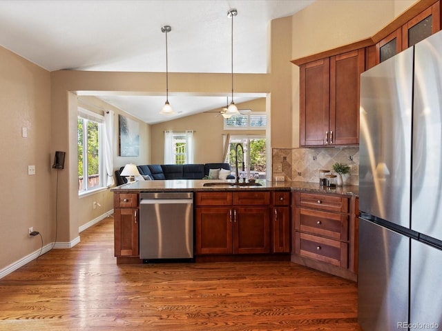 885 Sage Sparrow Cir, Highlands Ranch, CO 80129 - kitchen featuring stainless steel appliances, wood finished floors, open floor plan, lofted ceiling, and plenty of natural light