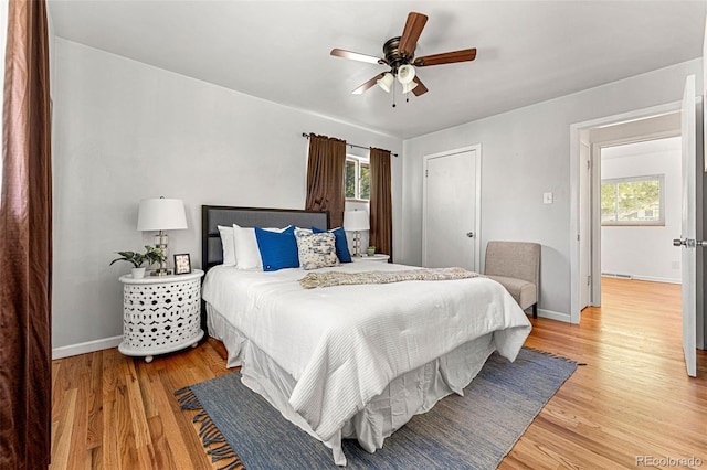 bedroom featuring light hardwood / wood-style flooring, multiple windows, and ceiling fan