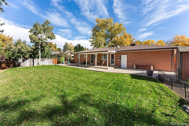 back of property featuring a patio area and a lawn