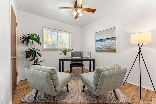 home office with light hardwood / wood-style floors and ceiling fan