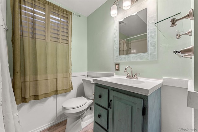 full bathroom with shower / tub combo with curtain, vanity, hardwood / wood-style flooring, and toilet