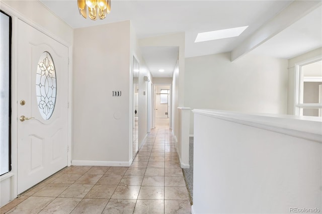 entrance foyer with a notable chandelier and vaulted ceiling with skylight