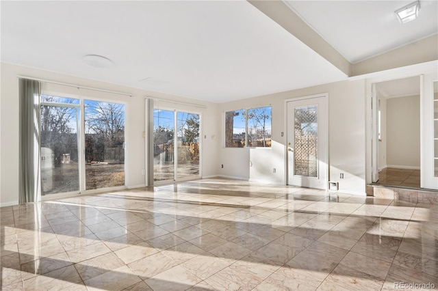 unfurnished room with a wealth of natural light and vaulted ceiling