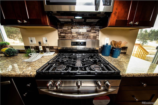 kitchen featuring appliances with stainless steel finishes, light stone countertops, and tasteful backsplash