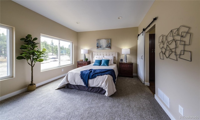 bedroom featuring multiple windows, a barn door, and carpet