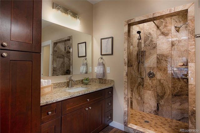 bathroom featuring wood-type flooring, vanity, and tiled shower