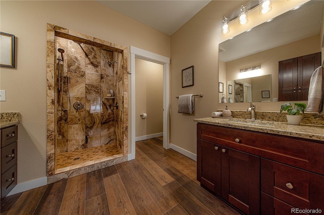 bathroom with wood-type flooring, vanity, and an enclosed shower