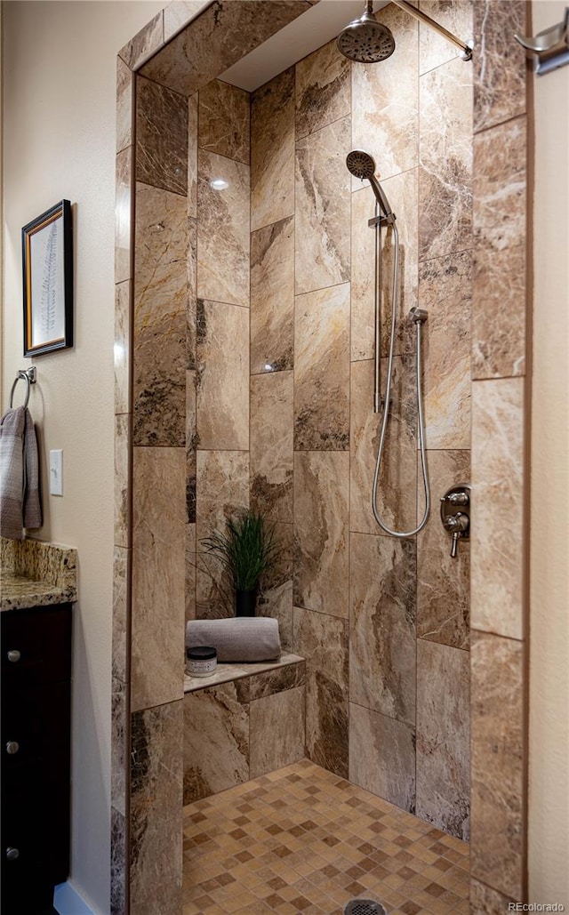 bathroom featuring a tile shower and vanity