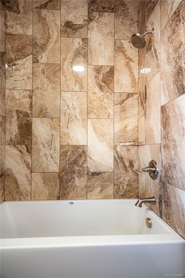 bathroom featuring tiled shower / bath