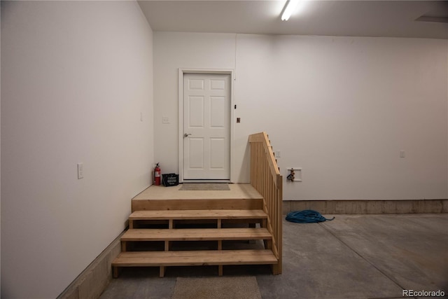 stairway with concrete flooring