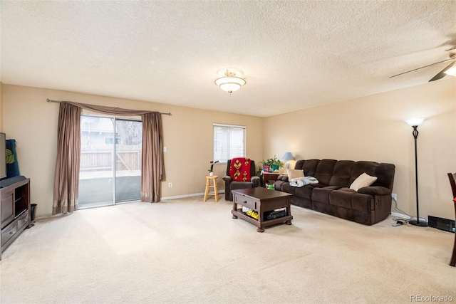 living area featuring carpet flooring, a ceiling fan, a textured ceiling, and baseboards