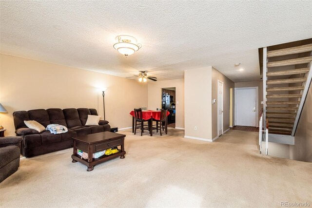 carpeted living room featuring baseboards, ceiling fan, and a textured ceiling