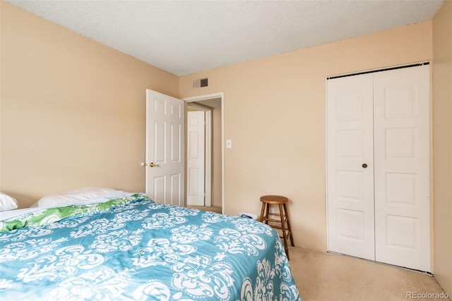 bedroom featuring visible vents, a closet, and light carpet