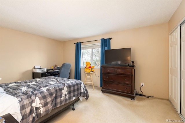 bedroom with light colored carpet and a closet