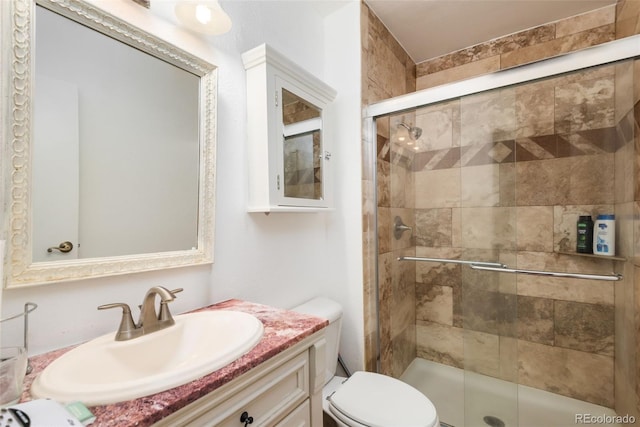 bathroom featuring vanity, a stall shower, and toilet
