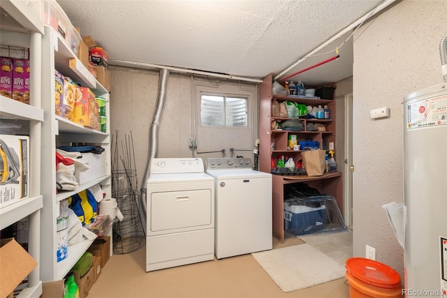 laundry area with water heater, laundry area, a textured ceiling, and washer and clothes dryer