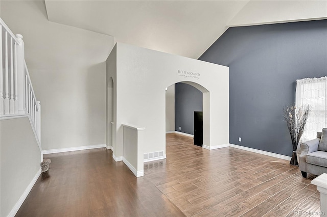 3163 E 133rd Ave, Thornton, CO 80241 - unfurnished room with arched walkways, high vaulted ceiling, wood finished floors, and stairway