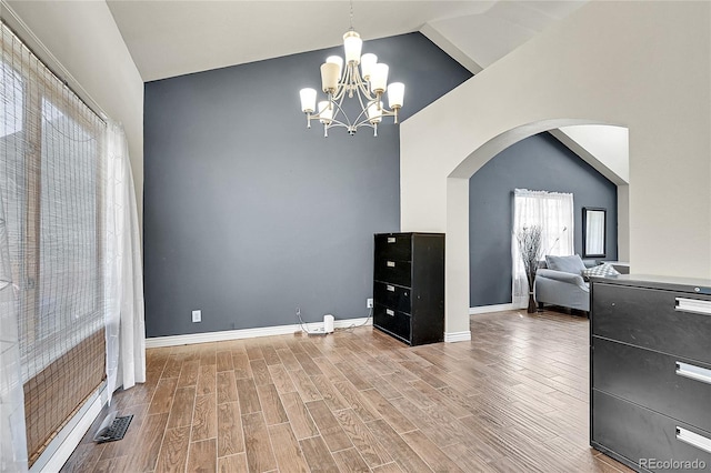3163 E 133rd Ave, Thornton, CO 80241 - dining space featuring arched walkways, a chandelier, wood finished floors, and high vaulted ceiling