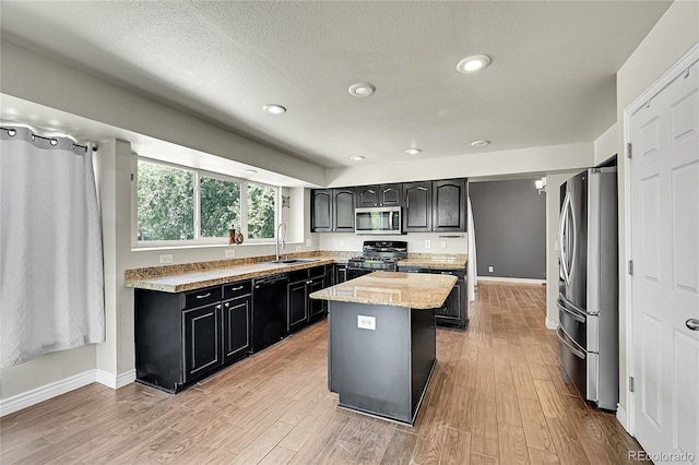 3163 E 133rd Ave, Thornton, CO 80241 - kitchen featuring appliances with stainless steel finishes, a center island, light wood finished floors, dark cabinets, and recessed lighting
