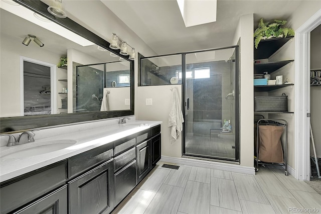 3163 E 133rd Ave, Thornton, CO 80241 - bathroom with double vanity, a stall shower, a walk in closet, and a skylight