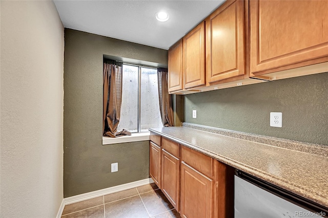 3163 E 133rd Ave, Thornton, CO 80241 - kitchen featuring tile patterned flooring, a textured wall, dishwasher, light countertops, and brown cabinets