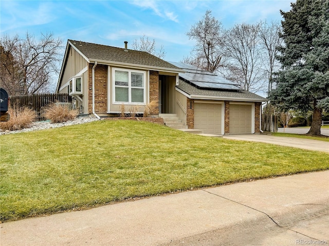 view of front of house featuring driveway, an attached garage, solar panels, and brick siding