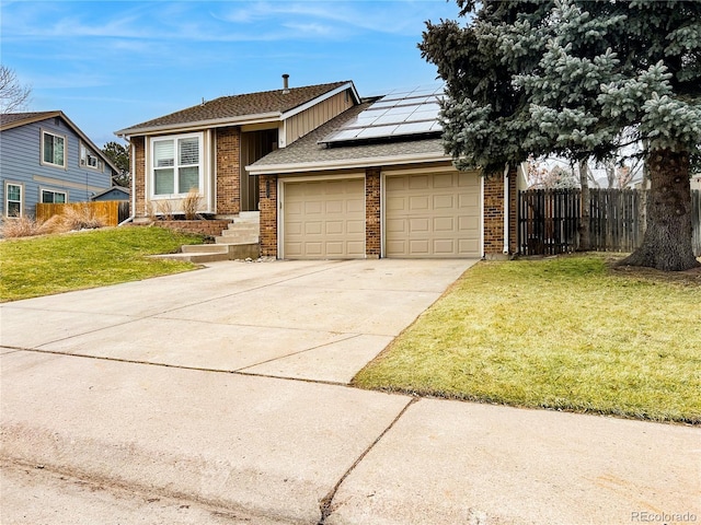 view of front of house with brick siding, concrete driveway, an attached garage, roof mounted solar panels, and fence