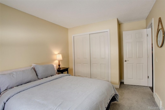 bedroom featuring baseboards, a closet, and light colored carpet