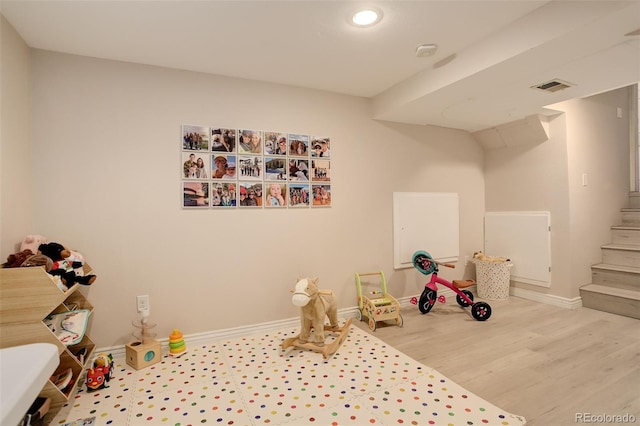 playroom featuring baseboards, visible vents, and wood finished floors