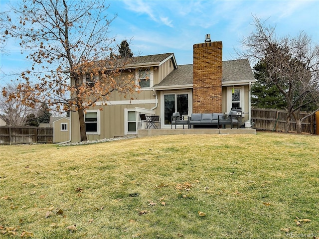 rear view of house featuring a chimney, a fenced backyard, a yard, and an outdoor living space