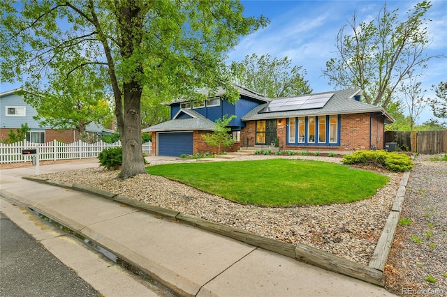 12355 E Arkansas Pl, Aurora, CO 80012 - split level home featuring brick siding, roof mounted solar panels, concrete driveway, and a shingled roof