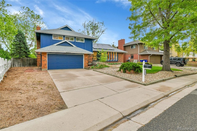 12355 E Arkansas Pl, Aurora, CO 80012 - tri-level home with brick siding, fence, roof mounted solar panels, a chimney, and concrete driveway