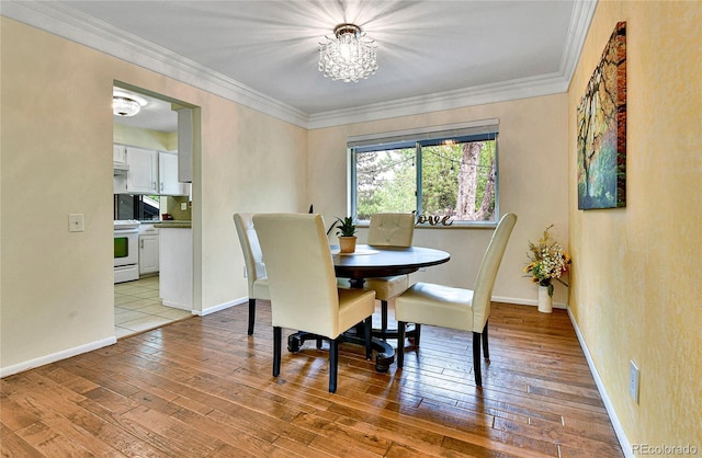 12355 E Arkansas Pl, Aurora, CO 80012 - dining area featuring hardwood / wood-style floors, ornamental molding, a chandelier, and baseboards