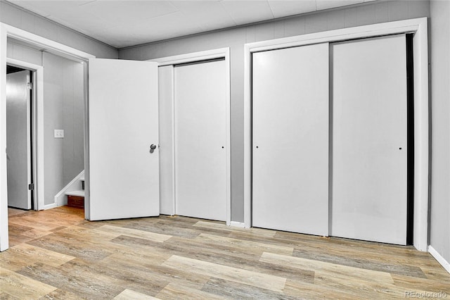 12355 E Arkansas Pl, Aurora, CO 80012 - unfurnished bedroom featuring two closets and light wood-style flooring