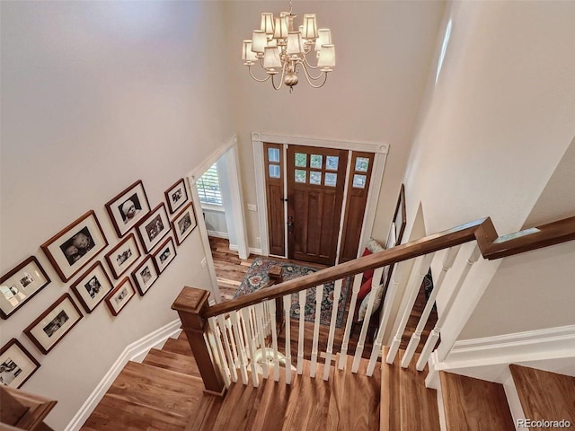 930 Kearney St, Denver, CO 80220 - foyer entrance with wood finished floors, a towering ceiling, stairway, and a chandelier