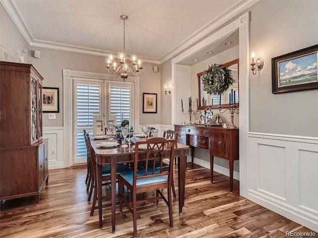 930 Kearney St, Denver, CO 80220 - dining space featuring a decorative wall, a chandelier, crown molding, wainscoting, and wood finished floors