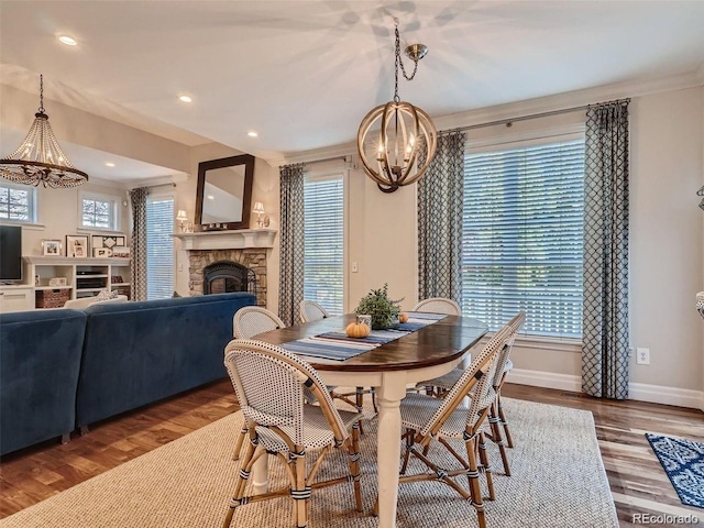 930 Kearney St, Denver, CO 80220 - dining room featuring a chandelier, a stone fireplace, wood finished floors, crown molding, and recessed lighting