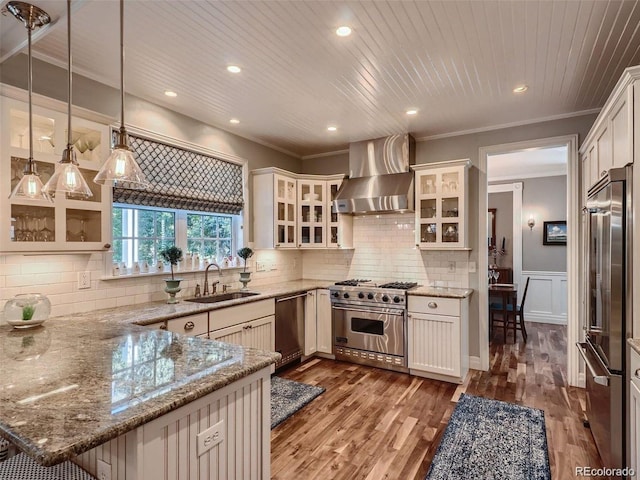 930 Kearney St, Denver, CO 80220 - kitchen featuring premium appliances, wall chimney exhaust hood, ornamental molding, a peninsula, and light stone countertops