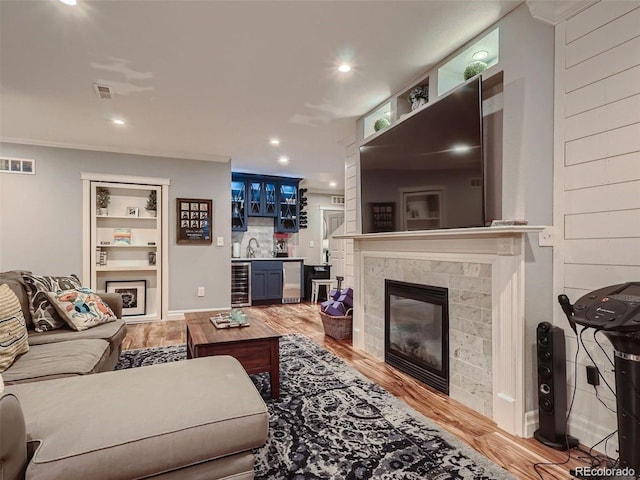 930 Kearney St, Denver, CO 80220 - living room with beverage cooler, a tile fireplace, bar, light wood finished floors, and recessed lighting